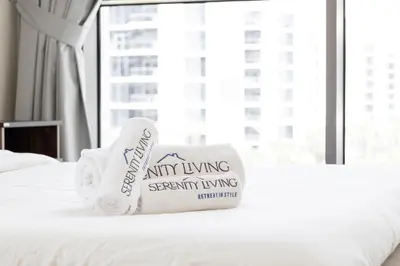a hotel room with towels on a bed with a window at Serenity Living - stunning 1BR, DAMAC Hills in Dubai
