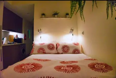 a bedroom with a bed with red and white pillows at Chic and Cozy Studio in Dubai
