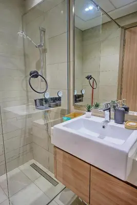 a bathroom with a white sink and a shower at Chic and Cozy Studio in Dubai