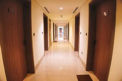 a long hallway of a building with wooden doors at Chic and Cozy Studio in Dubai