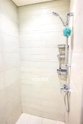 a shower with a shower head in a bathroom at Cozy Crib in Dubai