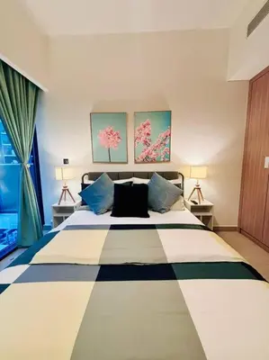 a bedroom with a large bed with two lamps at Heavenly Adobe in Dubai