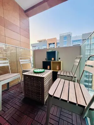 a balcony with a bench and a table and chairs at Heavenly Adobe in Dubai