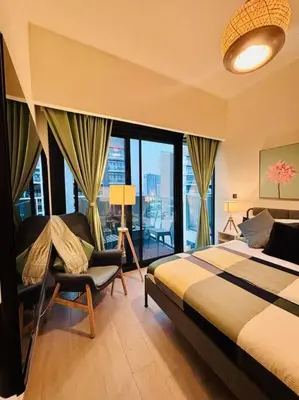 a bedroom with a bed and a chair and a window at Heavenly Adobe in Dubai