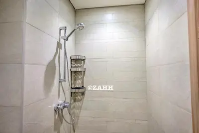 a shower with a glass door in a bathroom at Studio Haven in Dubai