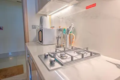 a kitchen counter with a stove and a microwave at Studio Haven in Dubai