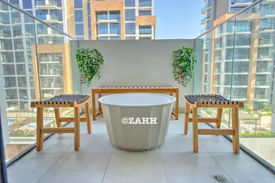 a table and two chairs and a trash can on a balcony at Studio Haven in Dubai