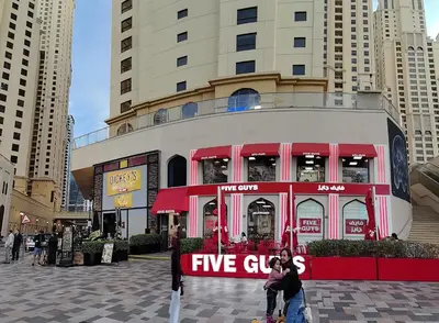 a group of people standing in front of a five store at New Horizon 2 Bedroom LUXURY APARTMENT JBR MARINA in Dubai