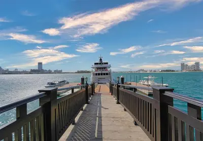 a ferry boat on a dock in the water at Palm Paradise 1BR - Beachfront Escape with Pool, Gym, Parking & Balcony in Dubai