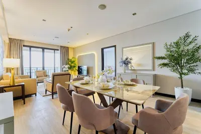 a dining room and living room with a table and chairs at Palm Paradise 1BR - Beachfront Escape with Pool, Gym, Parking & Balcony in Dubai