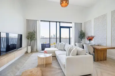 a white living room with a couch and a table at Daniels 1BR at Creek Edge with Waterfront View in Dubai