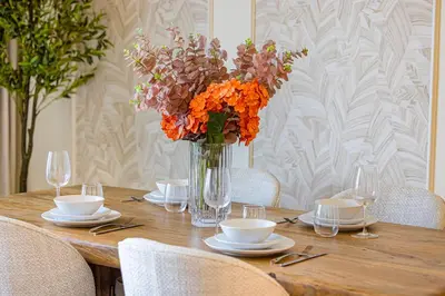 a wooden table with a vase of flowers on it at Daniels 1BR at Creek Edge with Waterfront View in Dubai