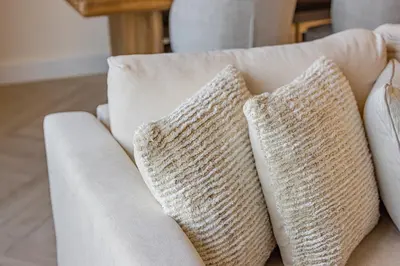 a white couch with two pillows on it at Daniels 1BR at Creek Edge with Waterfront View in Dubai