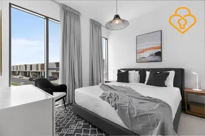 a bedroom with a bed and a large window at Keysplease 4BR Villa walking to pool, Cherrywoods Family Community in Dubai