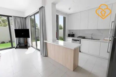 a kitchen with white cabinets and a tv in it at Keysplease 4BR Villa walking to pool, Cherrywoods Family Community in Dubai