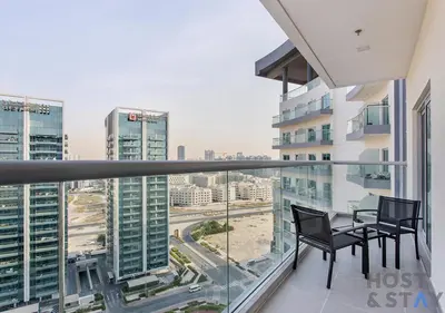 a balcony with a table and chairs on top of a building at Elegant 1BR Getaway in Bella Rose, Al Barsha in Dubai