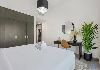 a bedroom with a large white bed and a mirror at Elegant 1BR Getaway in Bella Rose, Al Barsha in Dubai