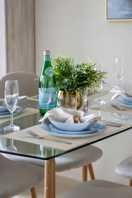 a glass table with a plate and a bottle at Frank Porter - Dunya Tower in Dubai