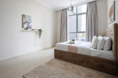 a bedroom with a large bed with a window at Frank Porter - Dunya Tower in Dubai