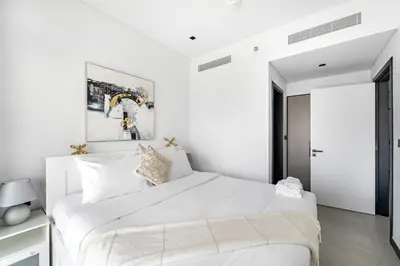 a white bedroom with a large bed and a window at 1 Bedroom with Canal View - 15 Northside in Dubai