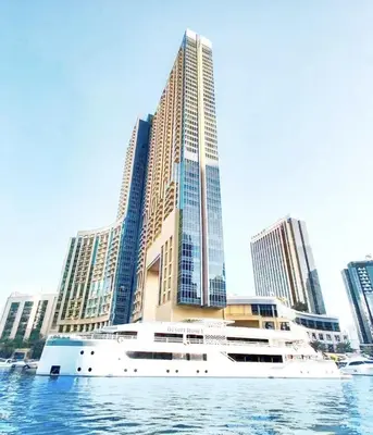 a cruise ship in front of a large building at Apartments in Address Dubai Marina Residences connected to Marina Mall in Dubai