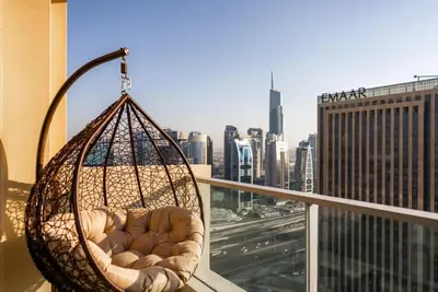 a hanging chair on a balcony with a view of a city at Apartments in Address Dubai Marina Residences connected to Marina Mall in Dubai