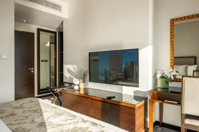 a bedroom with a large television on a wall at Apartments in Address Dubai Marina Residences connected to Marina Mall in Dubai