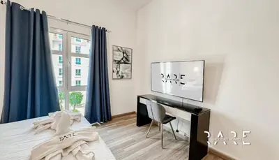 a bedroom with a bed and a desk and a window at Rare Holiday Homes - Mediterranean Cluster - Near Ibn Battuta Mall - Discovery Garden - Building# Med 49 - R213 in Dubai