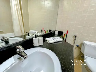 a bathroom with a sink and a toilet and a mirror at Rare Holiday Homes - Mediterranean Cluster - Near Ibn Battuta Mall - Discovery Garden - Building# Med 49 - R213 in Dubai