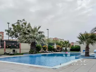 a swimming pool with palm trees in a resort at Rare Holiday Homes - Mediterranean Cluster - Near Ibn Battuta Mall - Discovery Garden - Building# Med 49 - R213 in Dubai