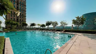 a swimming pool with blue water in a building at Cozy 1BR Near Dubai Hills Park in Dubai