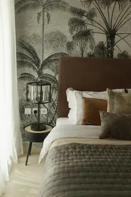 a bedroom with a bed and a wall with palm trees at Comfy stylish studio on the Palm in Dubai