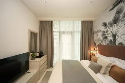 a bedroom with a large bed and a television at Comfy stylish studio on the Palm in Dubai