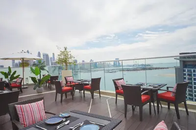 a restaurant with tables and chairs on a balcony at Comfy stylish studio on the Palm in Dubai