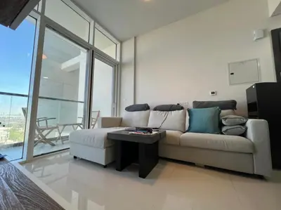 a living room with a couch and a table at Damac Golf vita in Dubai