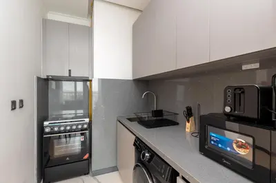 a kitchen with a stove and a microwave at Bespoke Holiday Homes - Mag Eye Residence in Dubai