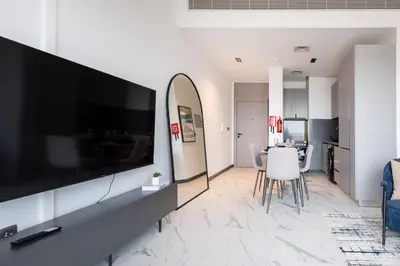 a living room with a large flat screen tv on a wall at Bespoke Holiday Homes - Mag Eye Residence in Dubai