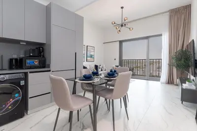 a kitchen and dining room with a table and chairs at Bespoke Holiday Homes - Mag Eye Residence in Dubai