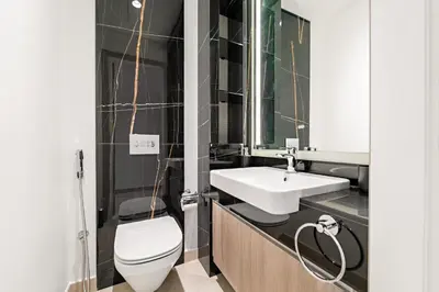 a bathroom with a white toilet and a sink at Stylish 1 BR Apartment close to JBR Beach in Dubai