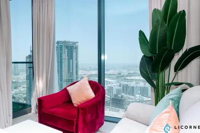 a red chair in a room with a large window at Luxury One BR in Sobha Hartland in Dubai