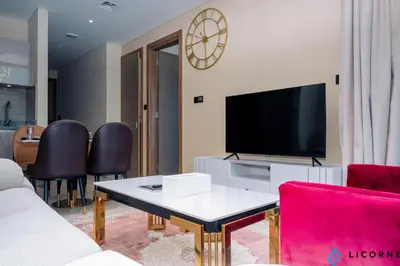 a living room with a couch and a tv at Luxury One BR in Sobha Hartland in Dubai