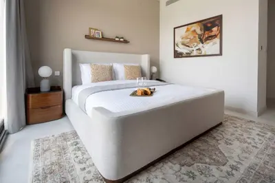 a large bed in a bedroom with a dog laying on it at Frank Porter - La Rosa 6 in Dubai