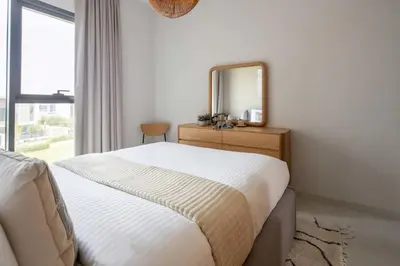 a bedroom with a bed with a mirror and a window at Frank Porter - La Rosa 6 in Dubai