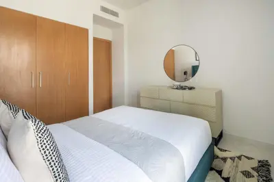 a bedroom with a white bed and a mirror at Frank Porter - La Rosa 6 in Dubai