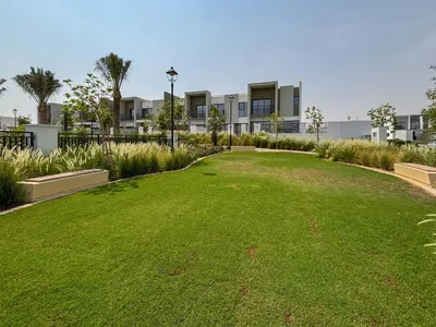 a large grassy yard in front of a building at Frank Porter - La Rosa 6 in Dubai