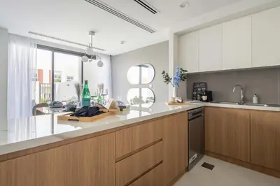 a kitchen with wooden cabinets and a counter top at Frank Porter - La Rosa 6 in Dubai