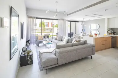 a living room with a couch and a kitchen at Frank Porter - La Rosa 6 in Dubai