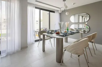 a dining room with a table and chairs and a mirror at Frank Porter - La Rosa 6 in Dubai