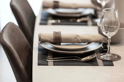 a table with a plate and a wine glass at City Views, Pool & Gym Near Iconic Burj Khalifa in Dubai