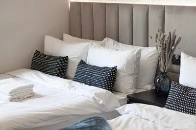 a bedroom with two beds with white sheets and pillows at City Views, Pool & Gym Near Iconic Burj Khalifa in Dubai